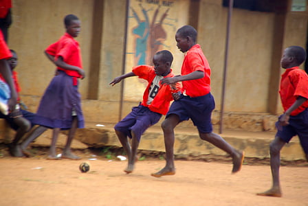 children playing ball game near brown concrete wall thumbnail