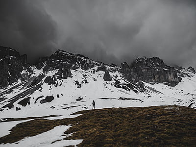 person standing near snow covered mountain taken during daytime thumbnail