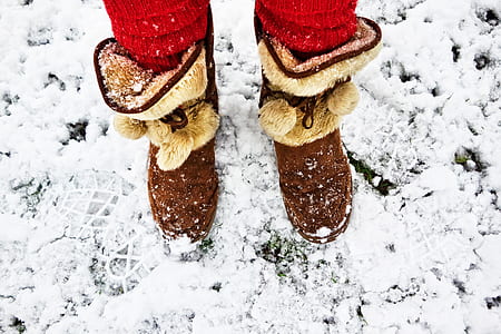 person wearing brown suede mid-calf mukluk boots at snow thumbnail