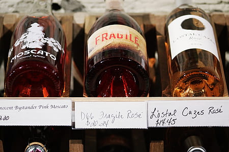 three wine bottles on wooden rack thumbnail