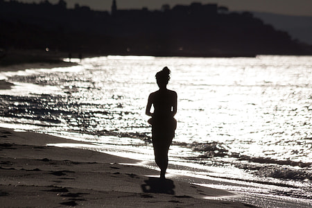 silhouette of woman walker on a sand near sea thumbnail