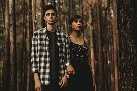 man and woman in formal attires walking under trees at daytime thumbnail