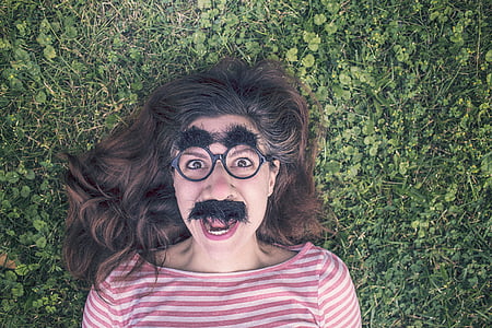 woman with fake mustache and eyebrow lying on green grass thumbnail