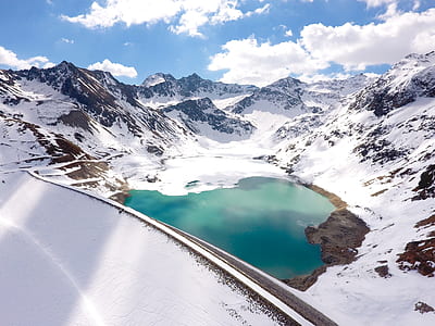 lake between snow capped mountain under white clouds during daytie thumbnail
