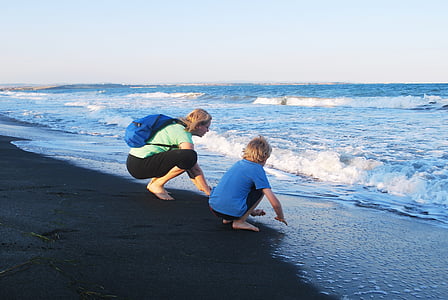girl and child sitting on seashore thumbnail