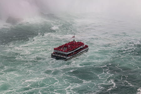 aerial photography of white and red boat sailing on large body of water thumbnail
