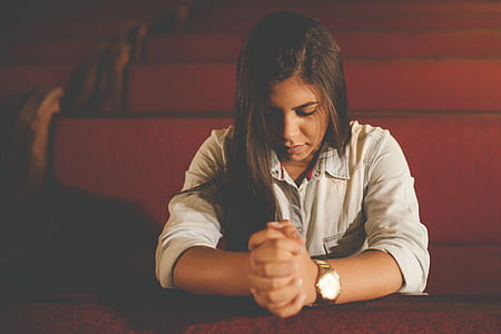 woman praying near chair thumbnail