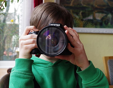 person using black Pentax SLR camera inside room thumbnail