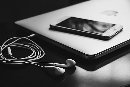 iPhone 6 on MacBook beside EarPods thumbnail