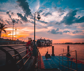 Group of People Watching Sunset on Harbor thumbnail
