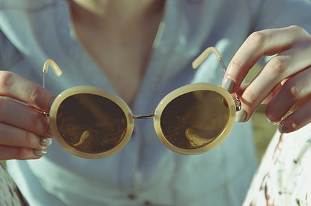 person's hand holding sunglasses thumbnail