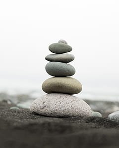 selective focus photography of stacked stones placed on gray sand thumbnail