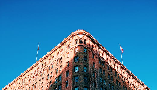 low-angle photography of brown concrete building under blue sky at daytime thumbnail
