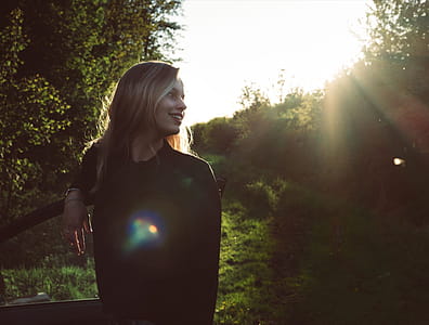 Woman Leaning on Car Door Under Sunny Sky thumbnail