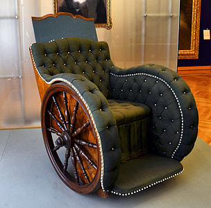 photo of brown wooden ship's wheel framed sofa with tufted black cushion thumbnail