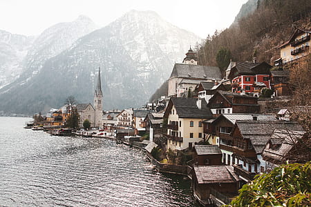 white-and-gray concrete buildings near body of water with mountain rang on the background thumbnail