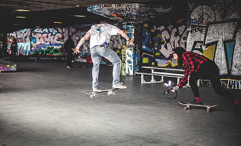 man wearing white shirt and jeans doing skateboard tricks thumbnail