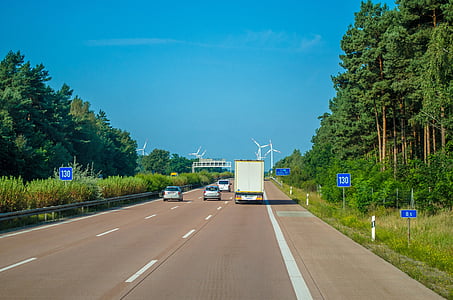 vehicles on road under blue sky during daytime thumbnail