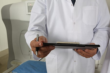 man wearing white coat holding black clipboard and pen thumbnail
