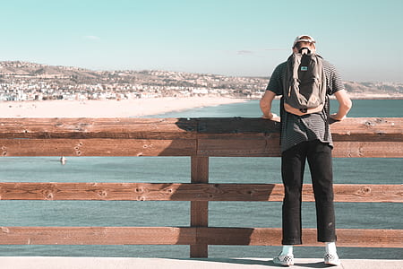 person standing near brown wooden bridge barricade thumbnail