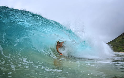 man surfing on wave during daytime thumbnail