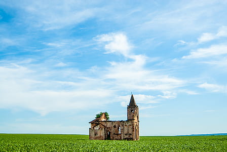 church surrounded by grass under sunny sky thumbnail