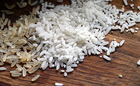 shallow photo of grains of rice on brown wooden surface thumbnail