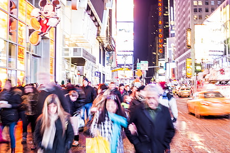 people walking between concrete buildings during nighttime thumbnail