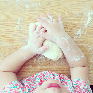 person hand holding dough on brown wooden board thumbnail