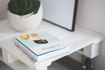 Small wooden table with a potted plant and a grey wallet thumbnail