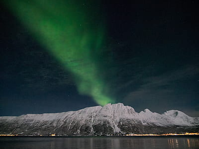 photo of snow coated mountain near body of water thumbnail