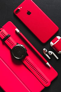 PRODUCT RED iPhone 7 Plus, AirPods, watch, and Apple Pencil on black surface thumbnail