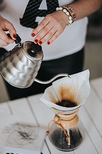 Woman pouring water in Chemex filter coffee maker thumbnail