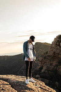 man standing on top of rock formation thumbnail