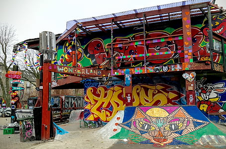 graffiti on red metal building during daytime thumbnail