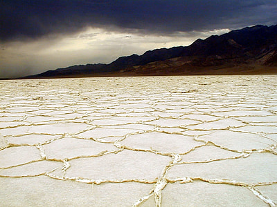 landscape photography of dry ground near mountain under nimbus cloud thumbnail