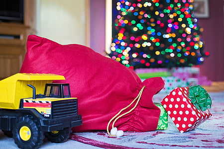 selective focus photography of yellow haul truck toy beside red drawstring bag thumbnail