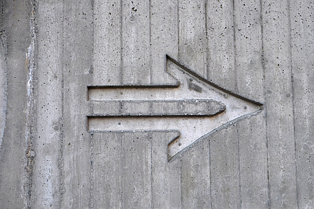 arrow engraved on brown wooden surface thumbnail