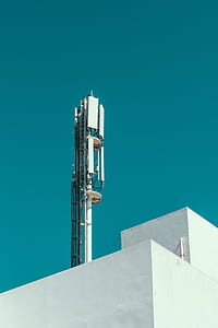 low-angle photography of white and gray antenna on white concrete building during daytime thumbnail