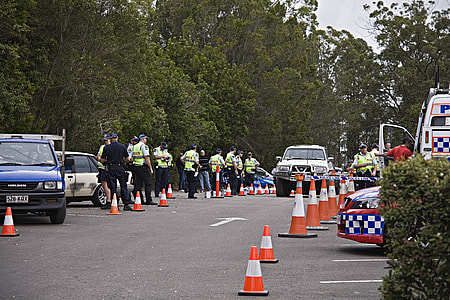 group of policeman standing near trees and vehicles thumbnail