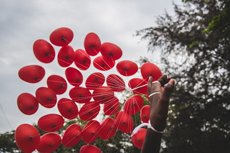 person holding red balloons thumbnail