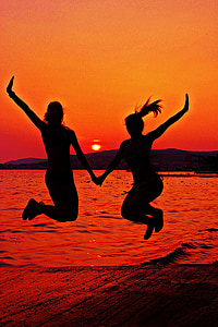 silhouette photo of two women jumping in beach thumbnail