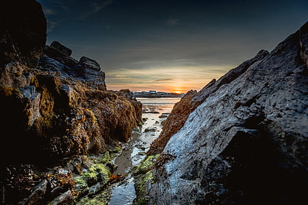 body of water between mountains during sunset thumbnail
