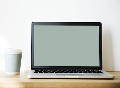 MacBook Pro beside travel mug thumbnail