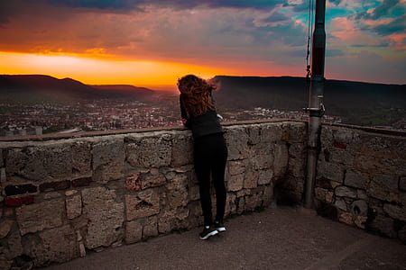 woman standing on balcony fence thumbnail