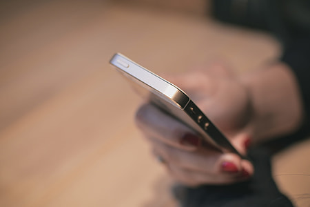person holding gold iPhone 5s selective-focus photo thumbnail