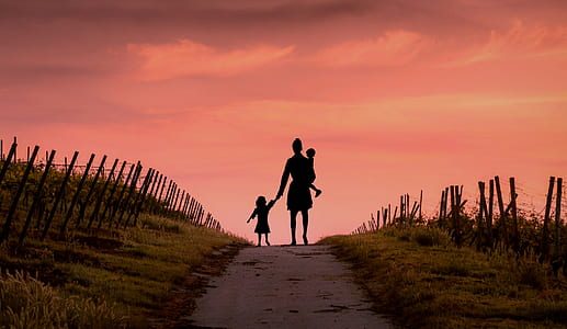 silhouette of woman holding girl and carrying baby thumbnail