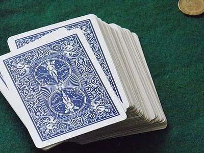stack of face down playing cards on green surface thumbnail