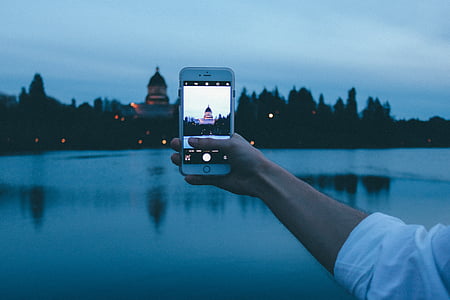 person holding iPhone 6 taking picture of building thumbnail
