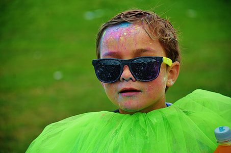 boy wearing black and green framed sunglasses with multi-color powder paint in face thumbnail
